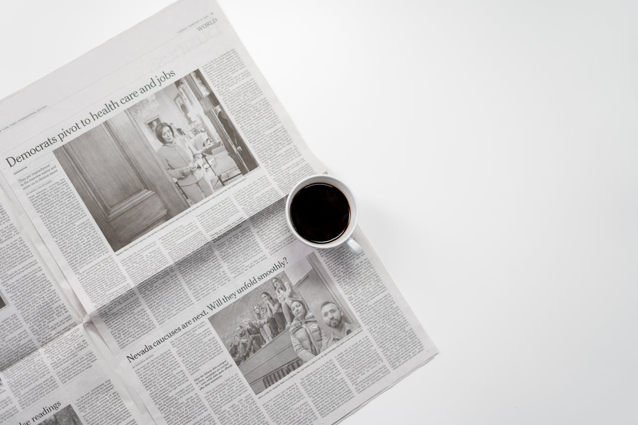 about-us A fresh cup of coffee resting on a newspaper, perfect morning routine setup.