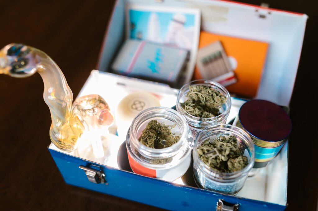 pexels photo 8139075 Open cannabis box containing weed, glass pipe, and rolling papers for legal use.