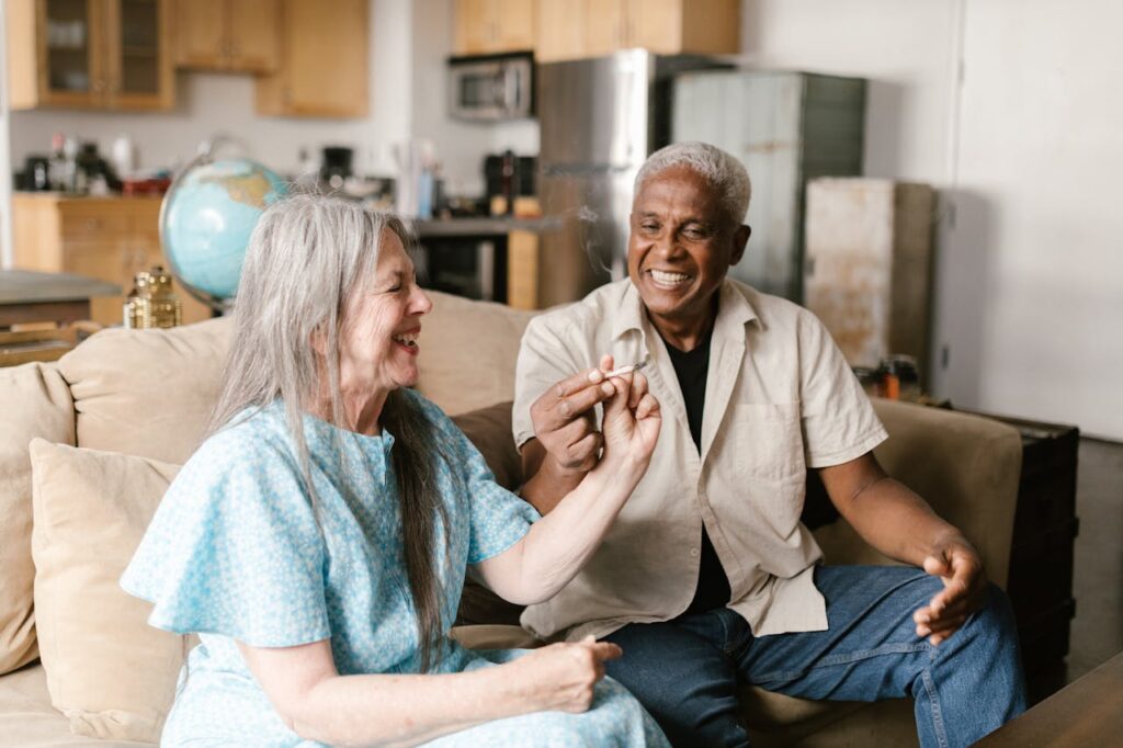pexels photo 8139247 Happy senior couple sharing a moment, smoking a joint in cozy indoor setting.